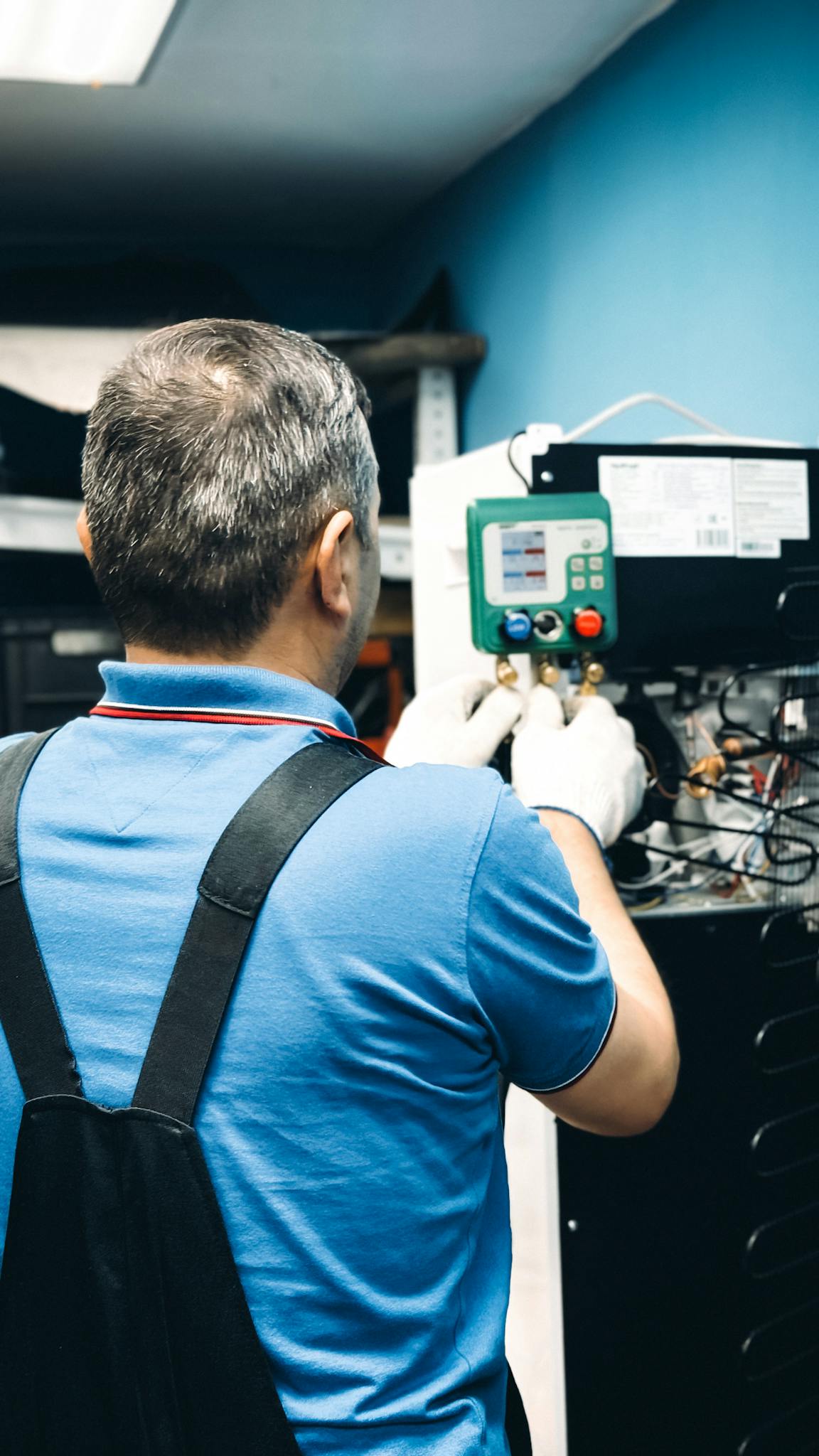 A skilled technician working on air conditioning system maintenance indoors.