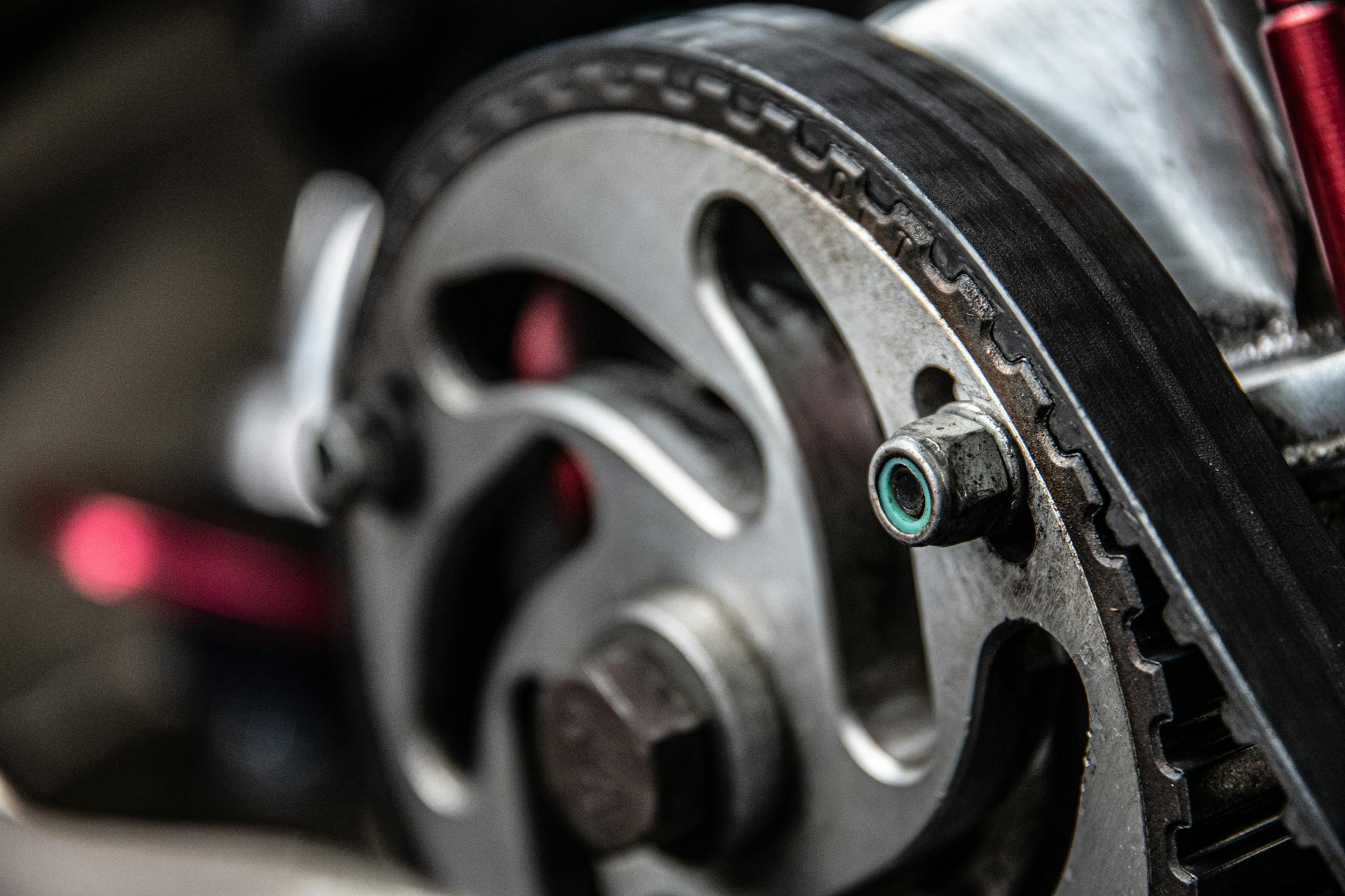 Focused shot of a car engine's metallic timing belt component, essential for maintenance and repair.